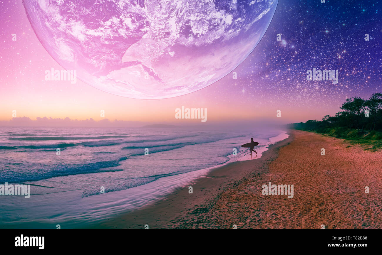 Paysage de fantaisie silhouette surfeur marche sur la plage de planète extra. Éléments de cette image fournie par la NASA Banque D'Images