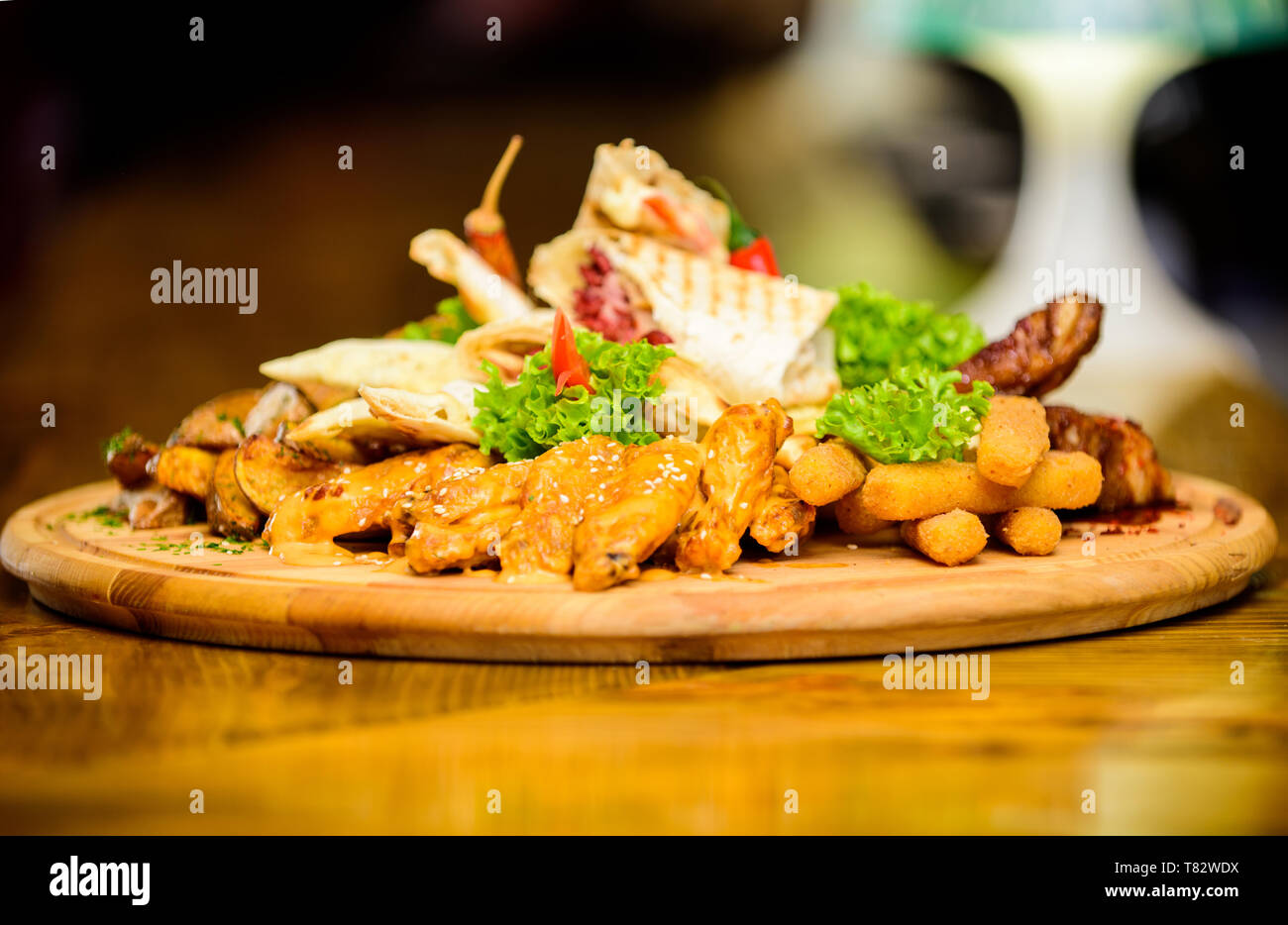 Planche de bois avec beaucoup de frites et bâtonnets de poisson viande burrito steak servi avec une salade. Menu snack-bar. Calories élevé pour le groupe d'amis. De délicieux en-cas savoureux. Snack pour la bière. Les repas au restaurant. Banque D'Images