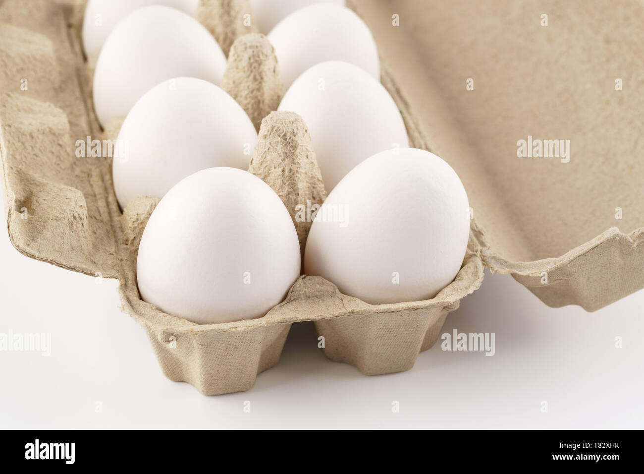 Les oeufs de poule dans une boîte, caisse, bac ou conteneur. Arrière-plan blanc. Banque D'Images