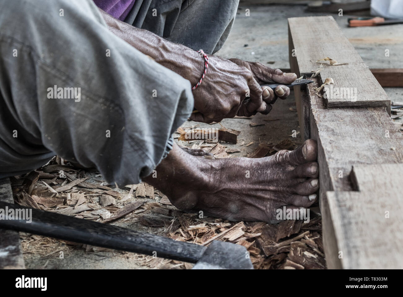 Close up d'avertir les mains de menuisier travaillant dans un atelier de menuiserie manuelle dans un pays du tiers monde. Banque D'Images