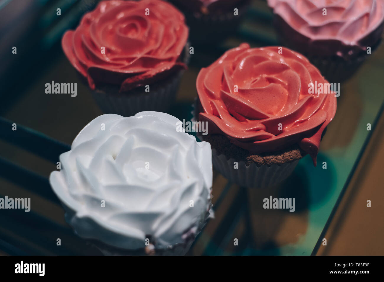 Cupcakes avec peach, blanc et rose rose cerise design. Focus sélectif. Copier l'espace. Banque D'Images