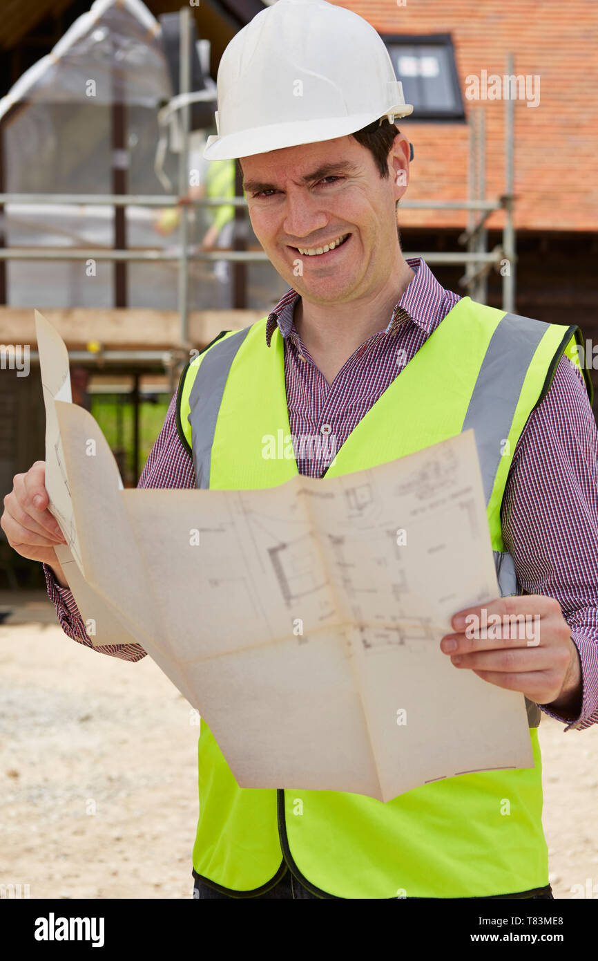 Portrait de l'architecte sur chantier Looking At House Plans Banque D'Images