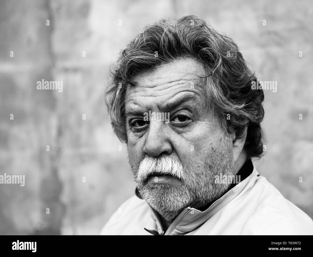 Portrait noir et blanc d'un couple d'âge moyen avec des cheveux gris, une moustache et une barbe sur fond gris Banque D'Images