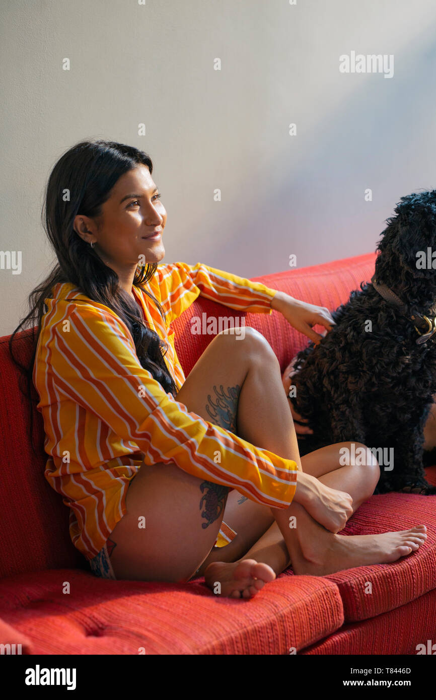 Hipster femme avec pet dog on sofa Banque D'Images