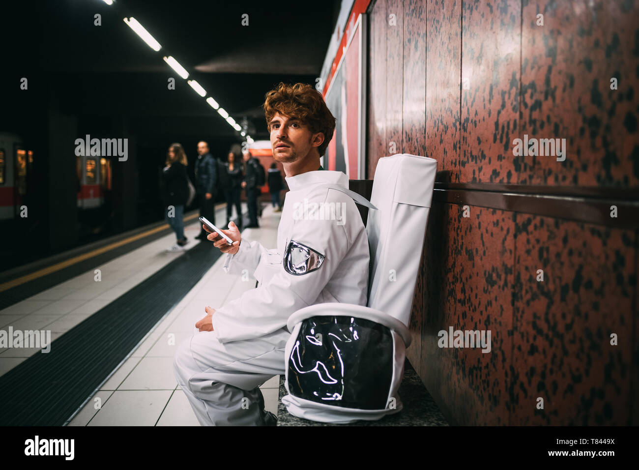 À l'aide de l'astronaute sur smartphone train platform Banque D'Images