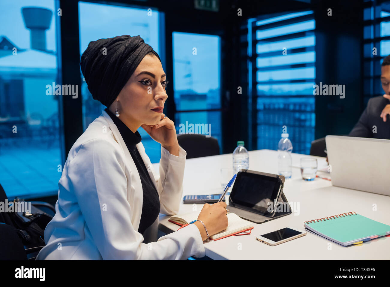Businesswoman listening au cours de réunion de la table de conférence Banque D'Images