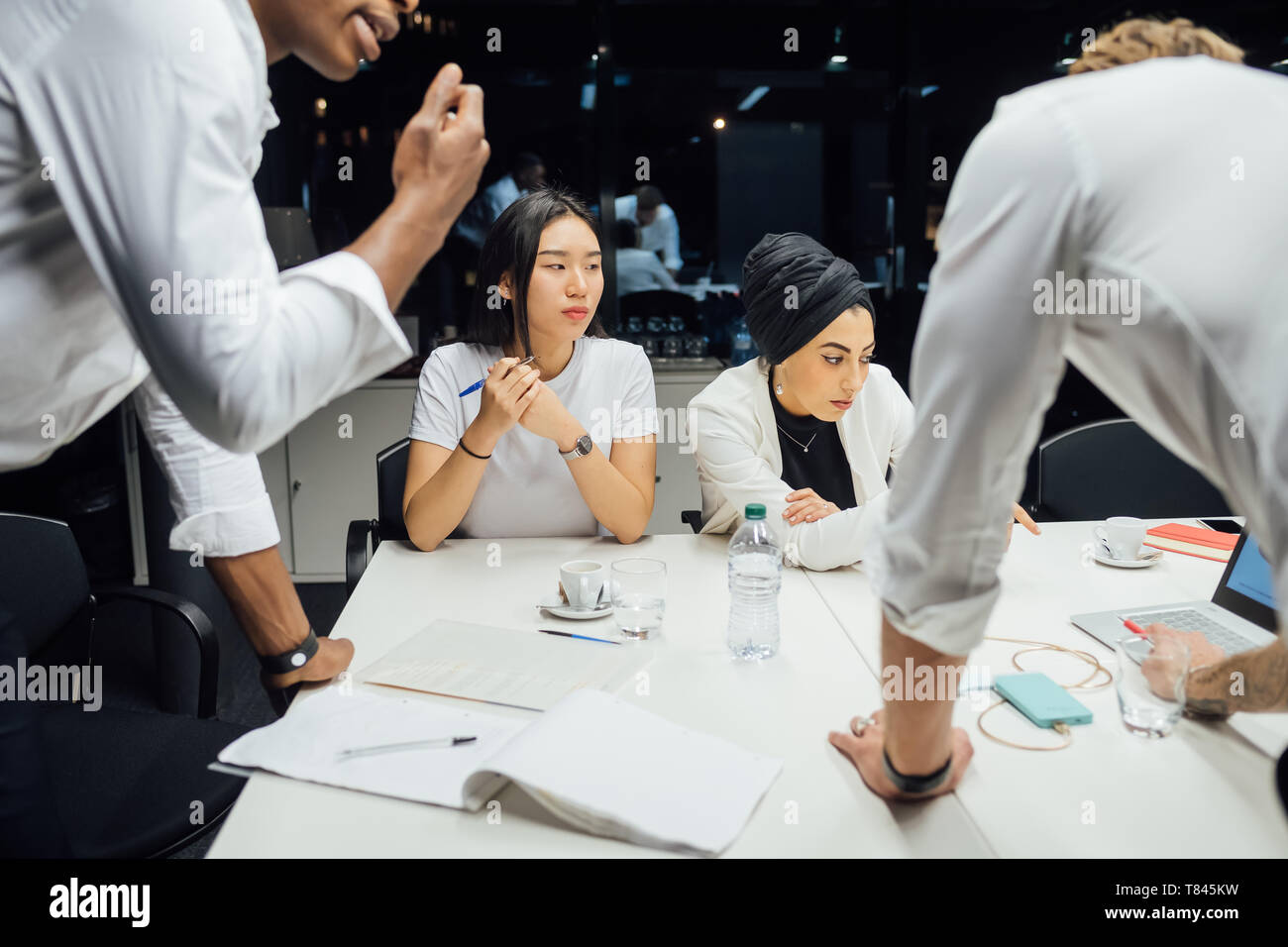 Les hommes et les femmes d'avoir discuté de la réunion de la table de conférence Banque D'Images