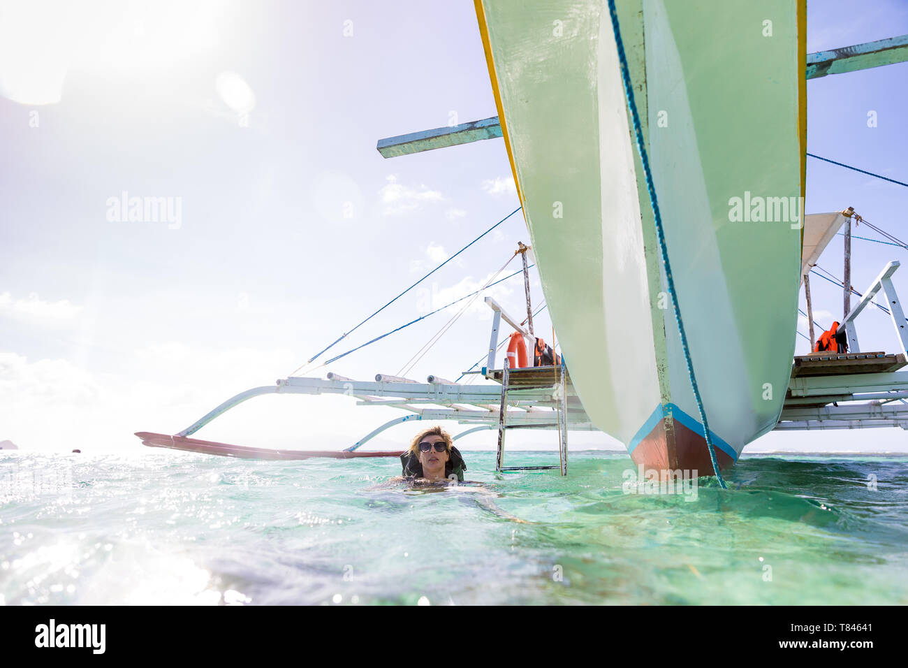 Une femme près de bateau amarré, Ginto, île Linapacan, Philippines Banque D'Images