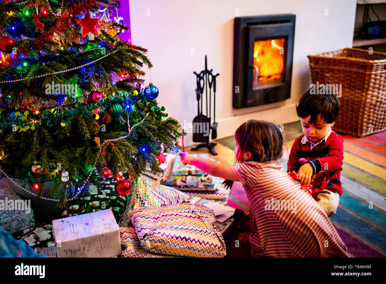 Fille et femme toddler playing par arbre de Noël de salon Banque D'Images