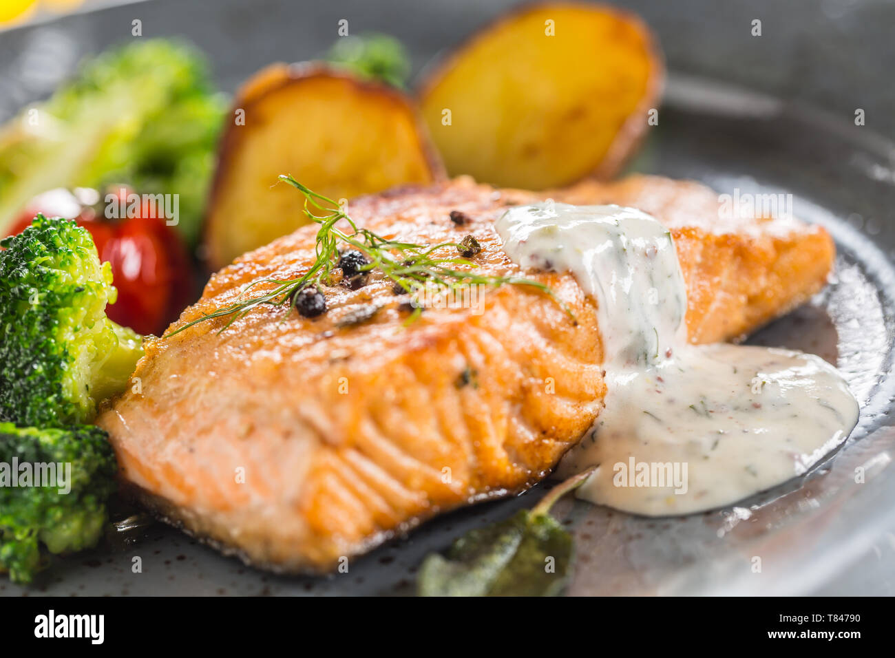Filet de saumon rôti tomates brocoli et pommes de terre frites avec sauce à la crème d'aneth Banque D'Images