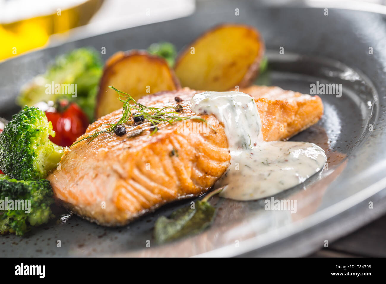 Filet de saumon rôti tomates brocoli et pommes de terre frites avec sauce à la crème d'aneth Banque D'Images