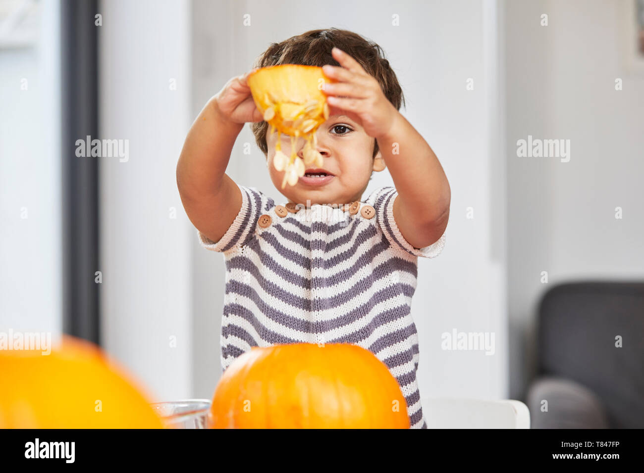 Boy holding up pumpkin core Banque D'Images
