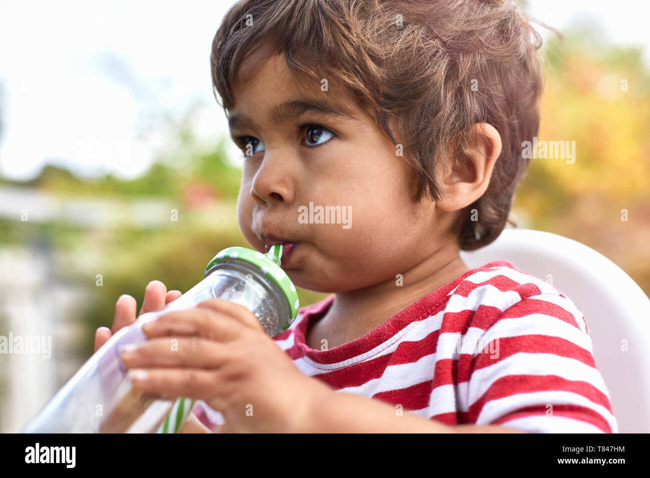 Boy drinking from le flacon en verre Banque D'Images