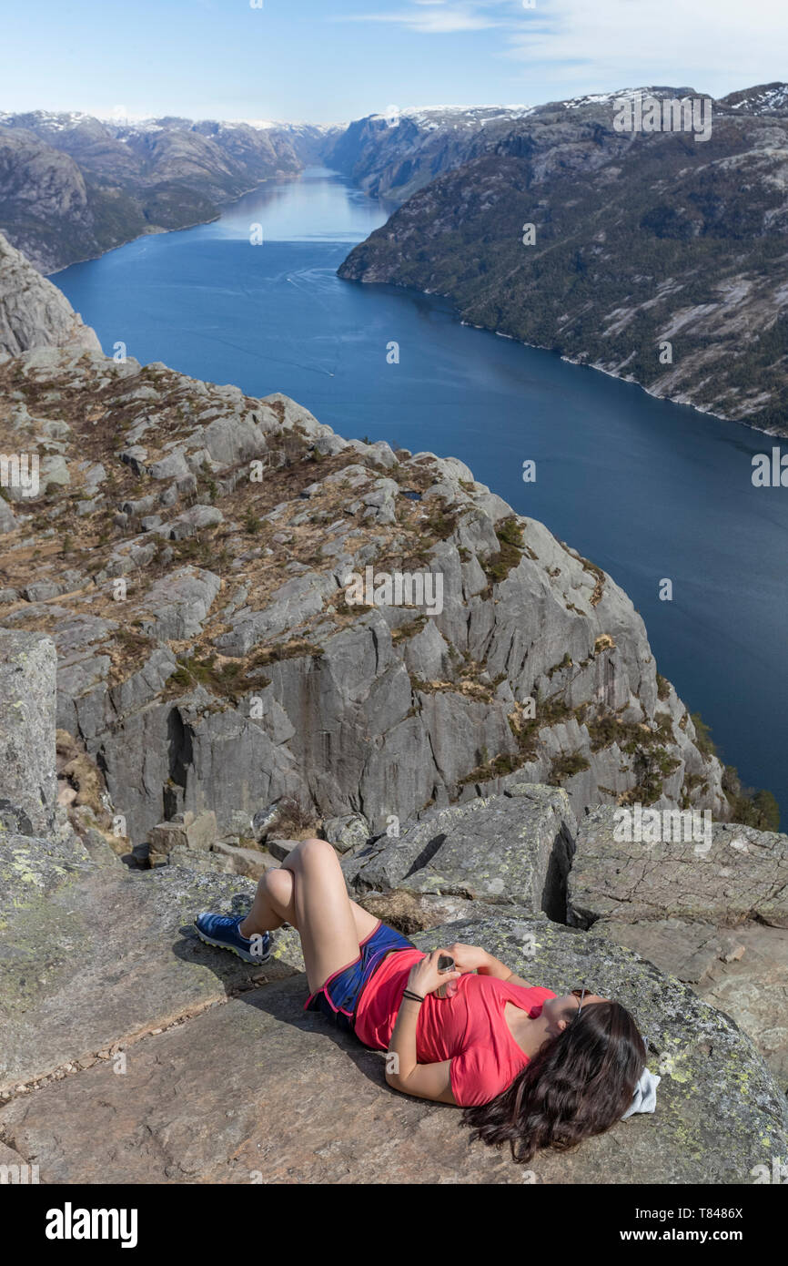 Randonneur reposant sur falaise, Preikestolen (Pulpit Rock), Lysefjord, Norvège, Stavanger Banque D'Images