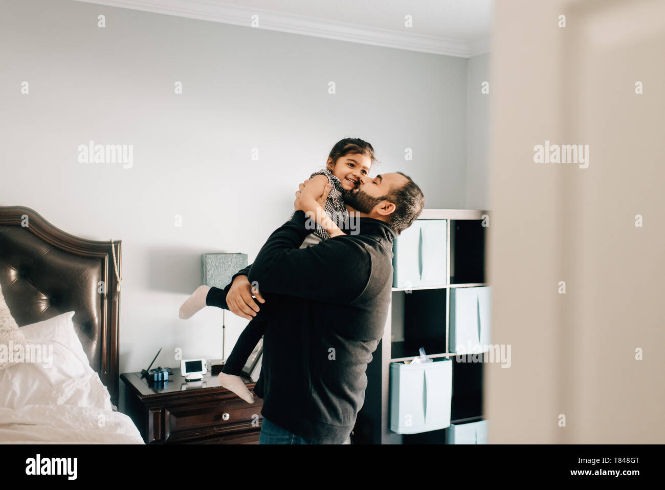 Girl en cours et embrassé par le père dans la chambre Banque D'Images