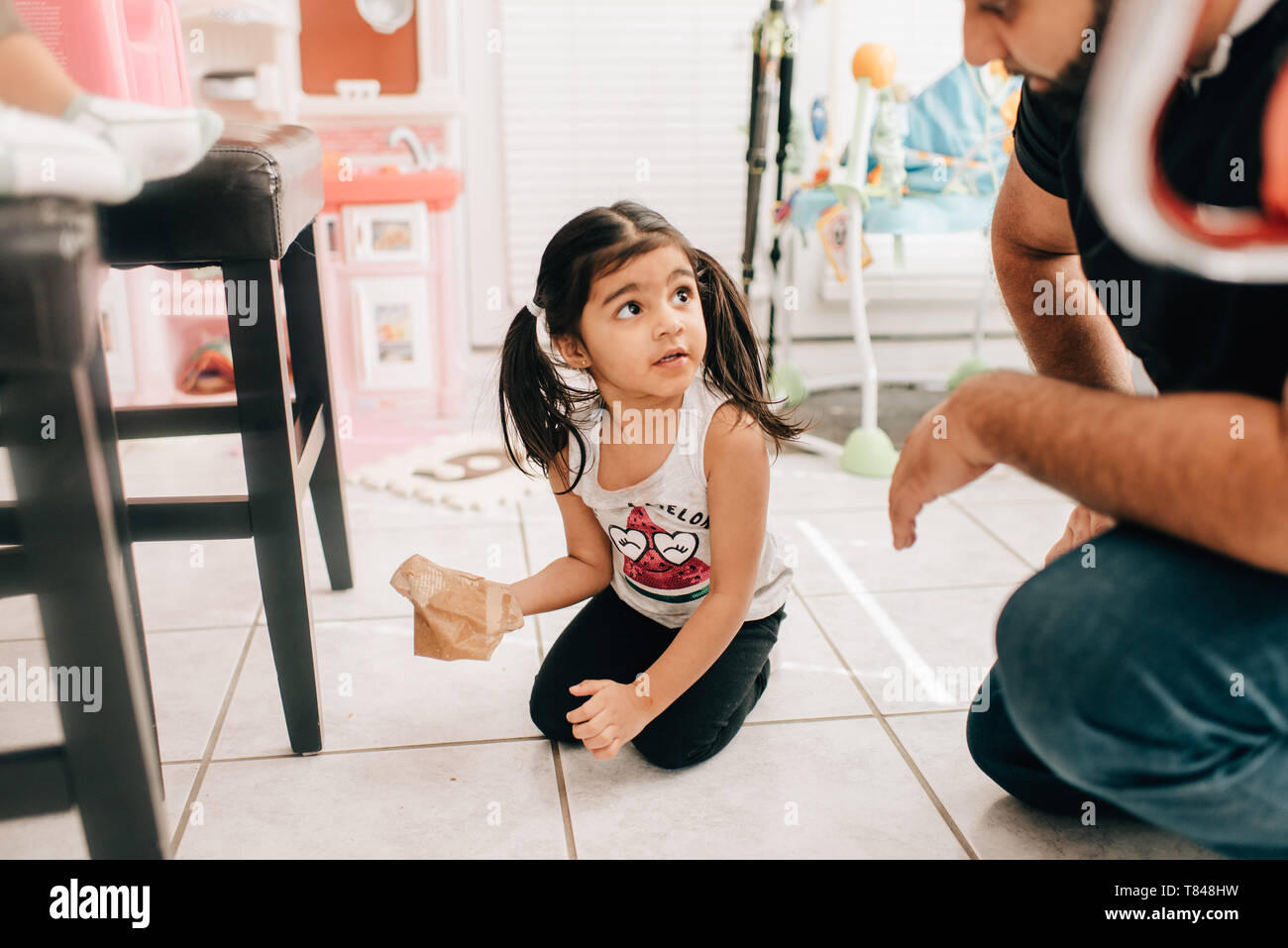 Essuyage fille plancher de la cuisine, le père regardant Banque D'Images