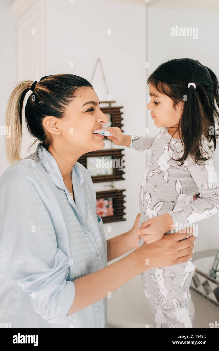 Le brossage des dents de la mère fille dans la salle de bains Banque D'Images