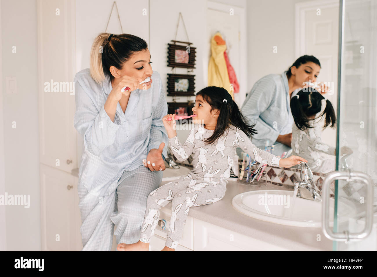 Mère et fille se brosser les dents dans la salle de bains Banque D'Images