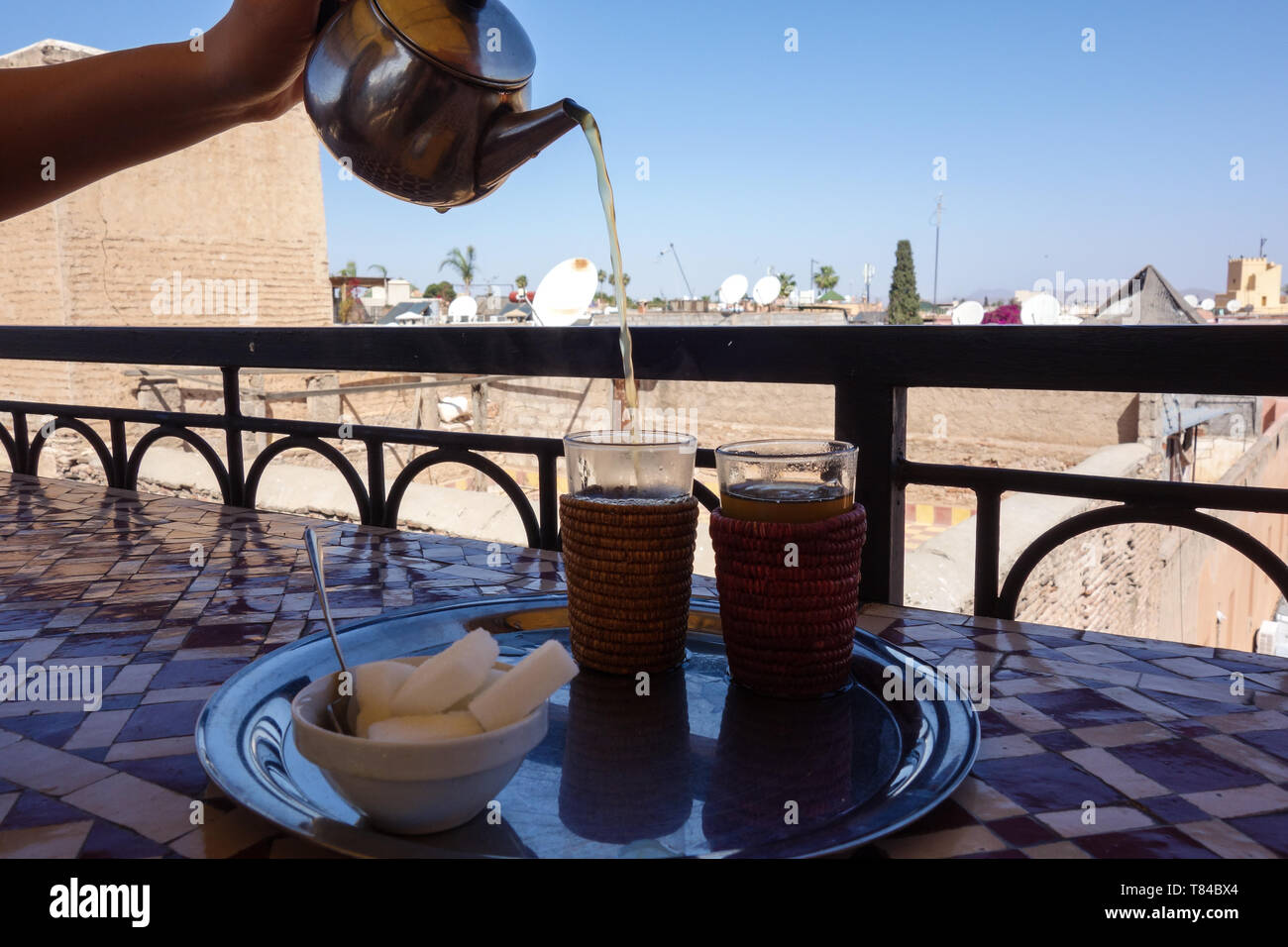 Thé à la menthe marocain traditionnel avec des bonbons servis dans un café à Marrakech, Maroc Banque D'Images