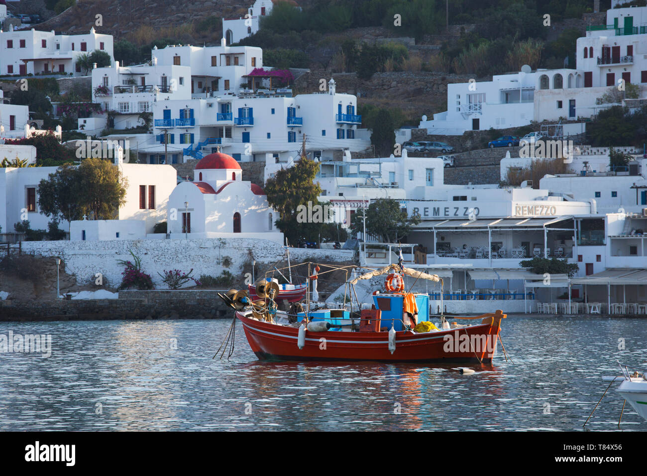 La ville de Mykonos, Mykonos, sud de la mer Egée, en Grèce. Bateau de pêche colorés amarrés dans le port, d'un dôme rouge en arrière-plan. Banque D'Images