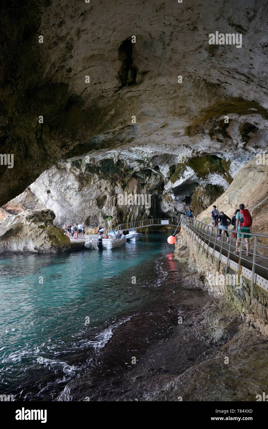 Les touristes s'approchant de l'entrée de Grotta del Bue Marino grottes calcaires complexe, golfe d'Orosei, parc national du Gennargentu, Cala Gonone, Sardaigne. Banque D'Images