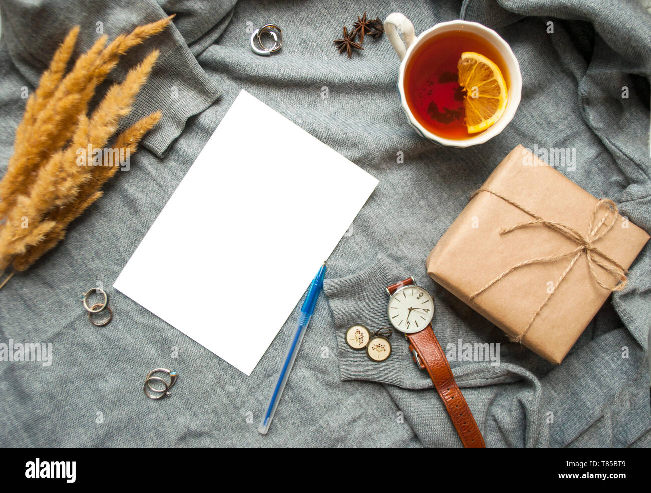 Belle tasse de thé au citron, et cértificat de différents accessoires sur fond tricoté gris . Automne-hiver confortable concept. Banque D'Images