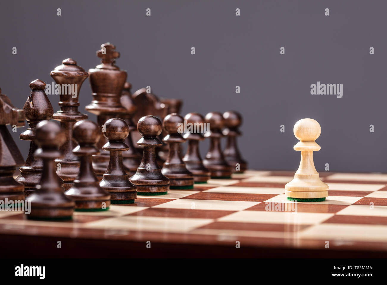 Un pion debout contre l'ensemble des chiffres d'Échecs Pièces à bord Banque D'Images