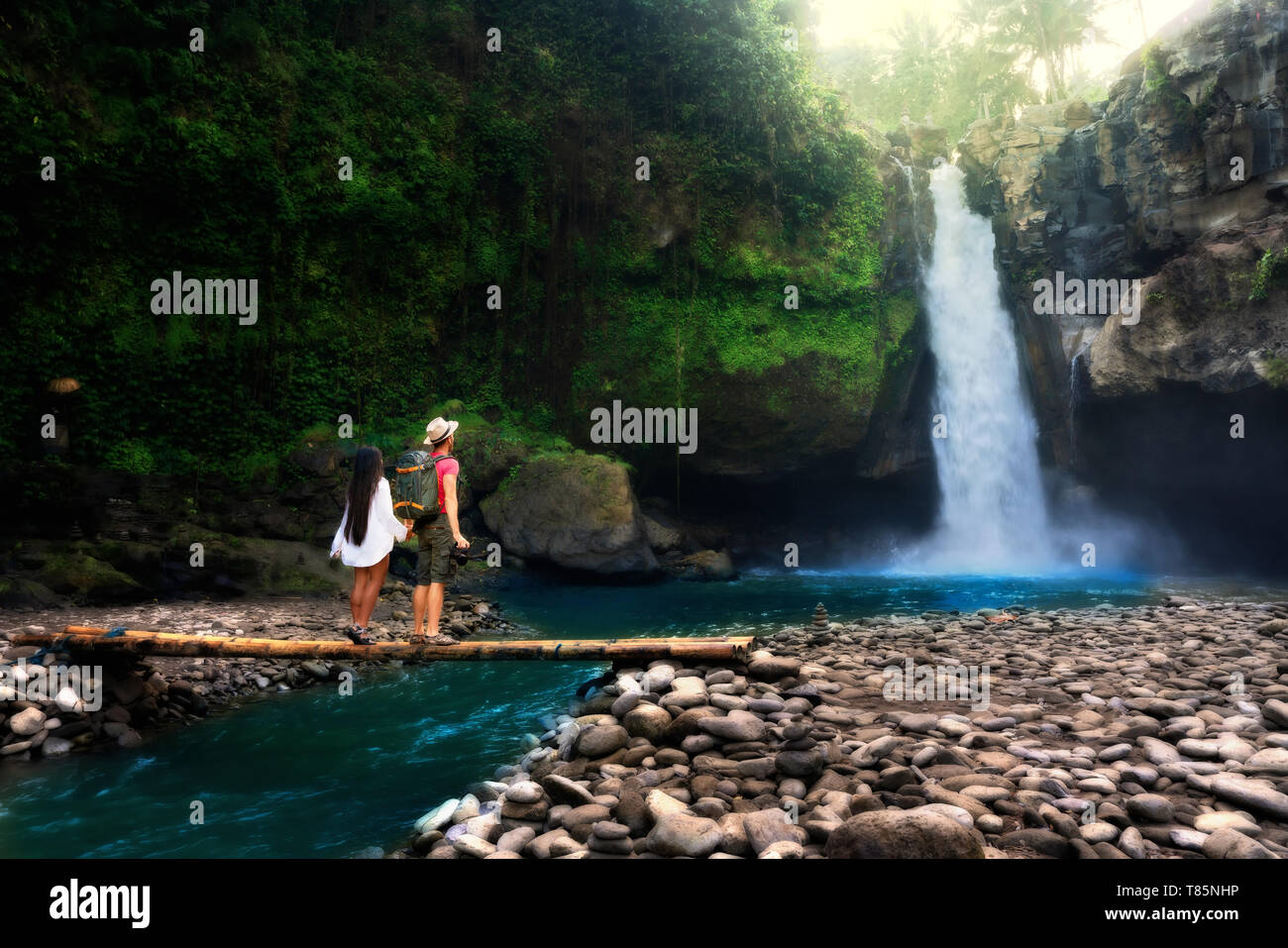 Jeune couple debout près du ruisseau, avec l'homme de prendre des photos de cascade. Couple d'apprécier dans la nature. Banque D'Images