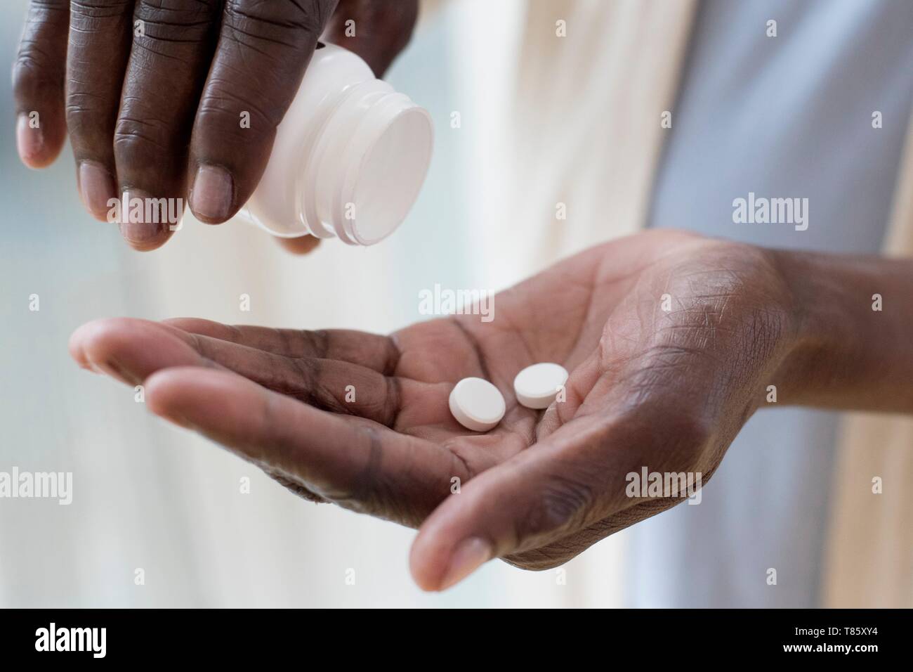 Woman pouring pills Banque D'Images