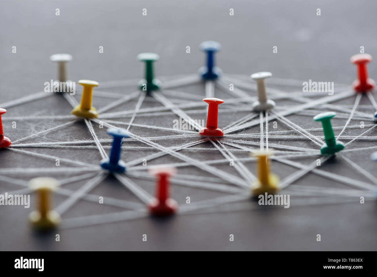 Focus sélectif des punaises de couleur connecté avec les cordes sur gray, réseau concept Banque D'Images