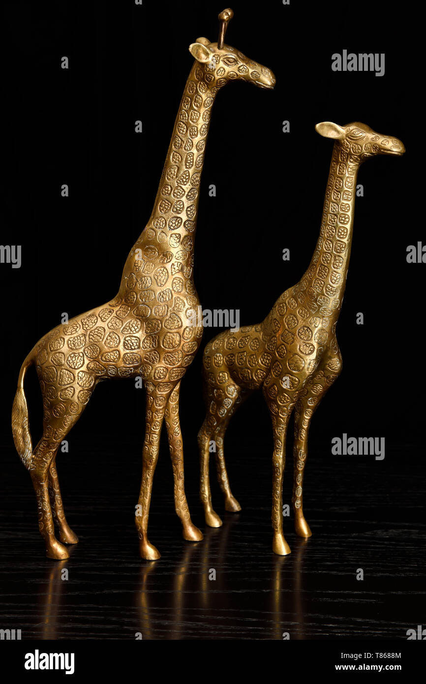 Deux statuettes en laiton des girafes sur une table en chêne noir Banque D'Images