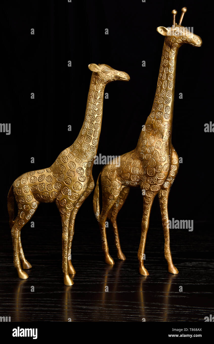 Deux figurines en laiton des girafes sur une table en chêne noir Banque D'Images