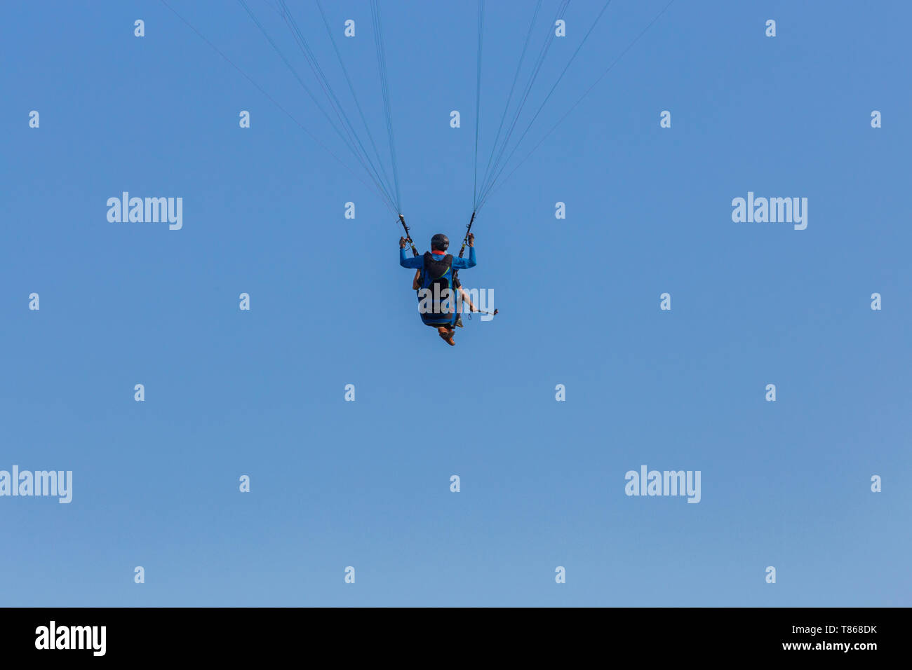 Parapente en tandem à travers ciel bleu flottant en suspension sur l'équipement Banque D'Images