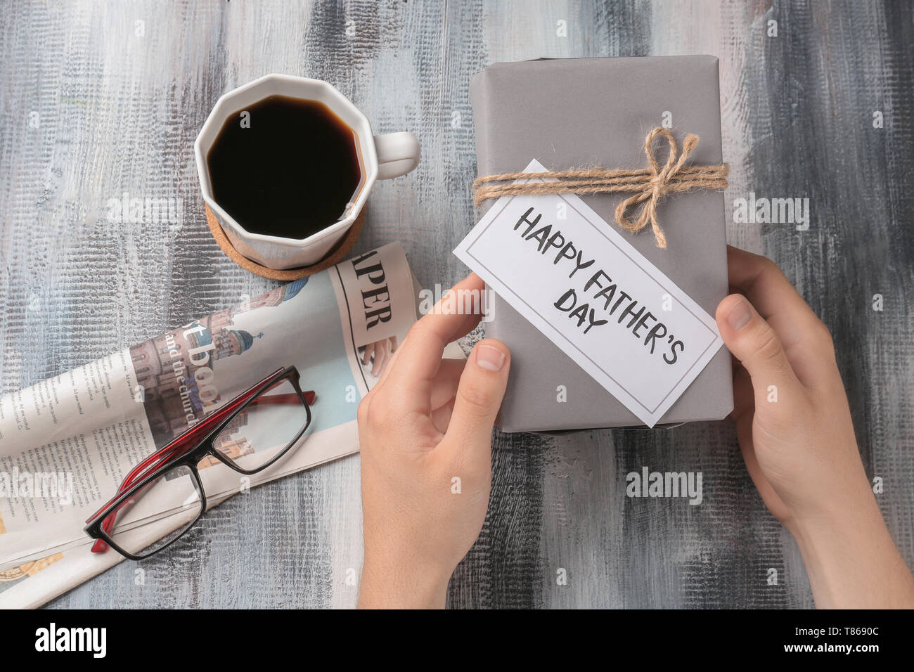 Man holding gift box avec HAPPY FATHER'S DAY card sur table Banque D'Images