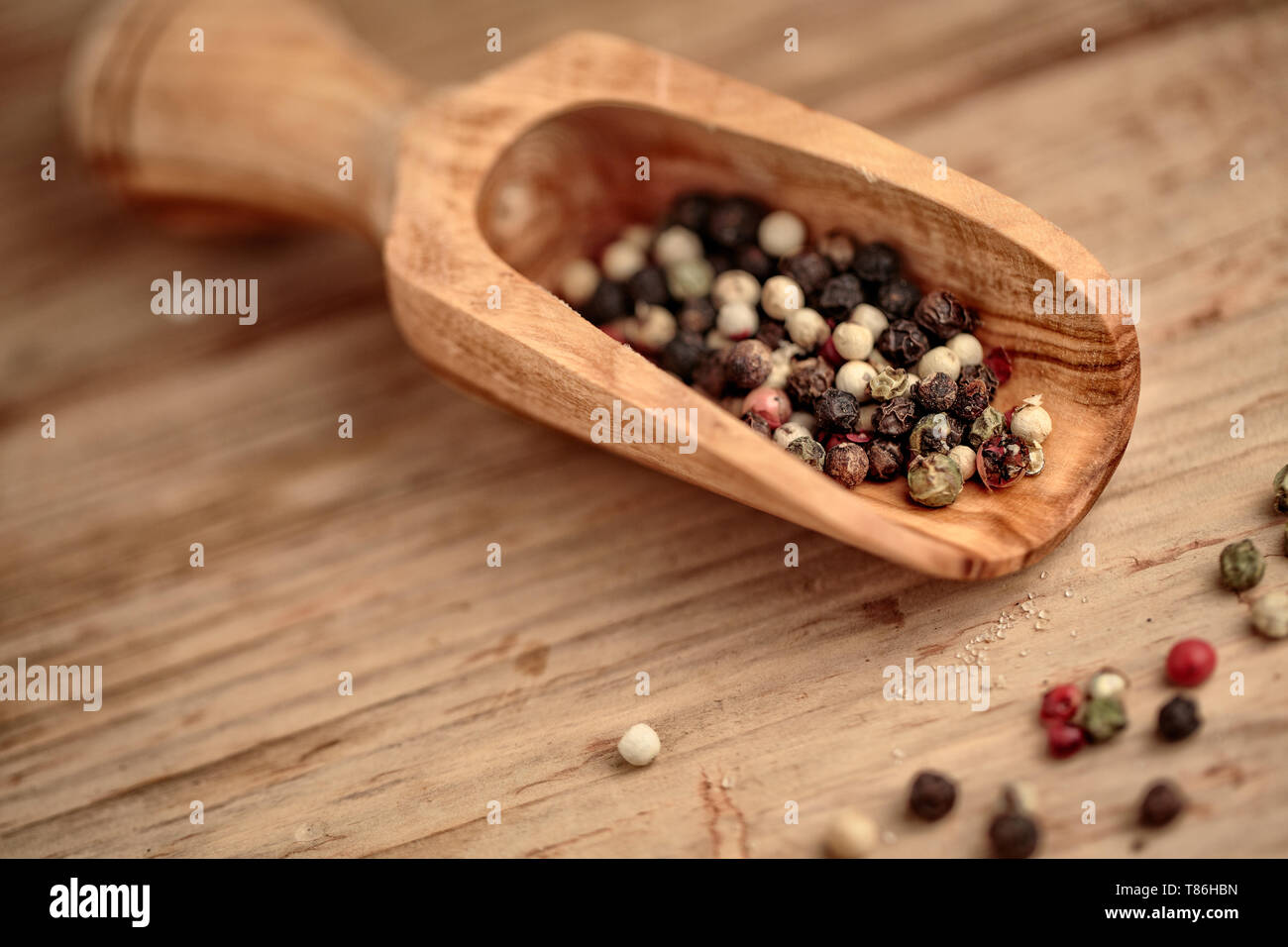 Mélanger le poivre colorés de grains entiers dans scoop en bois Banque D'Images