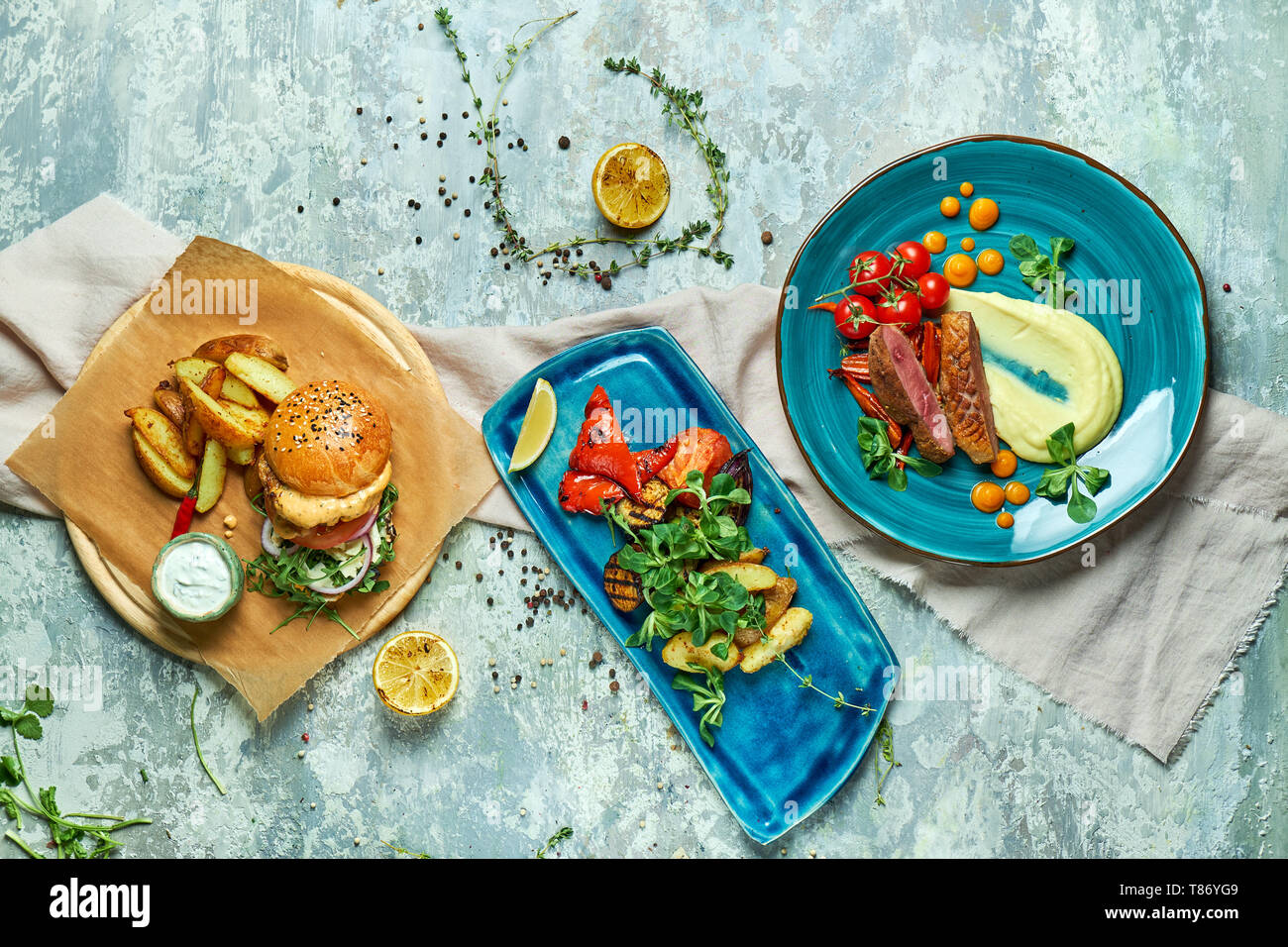 Trois plats avec burger de viande avec légumes grillés voir l'svrhu sur fond gris Banque D'Images