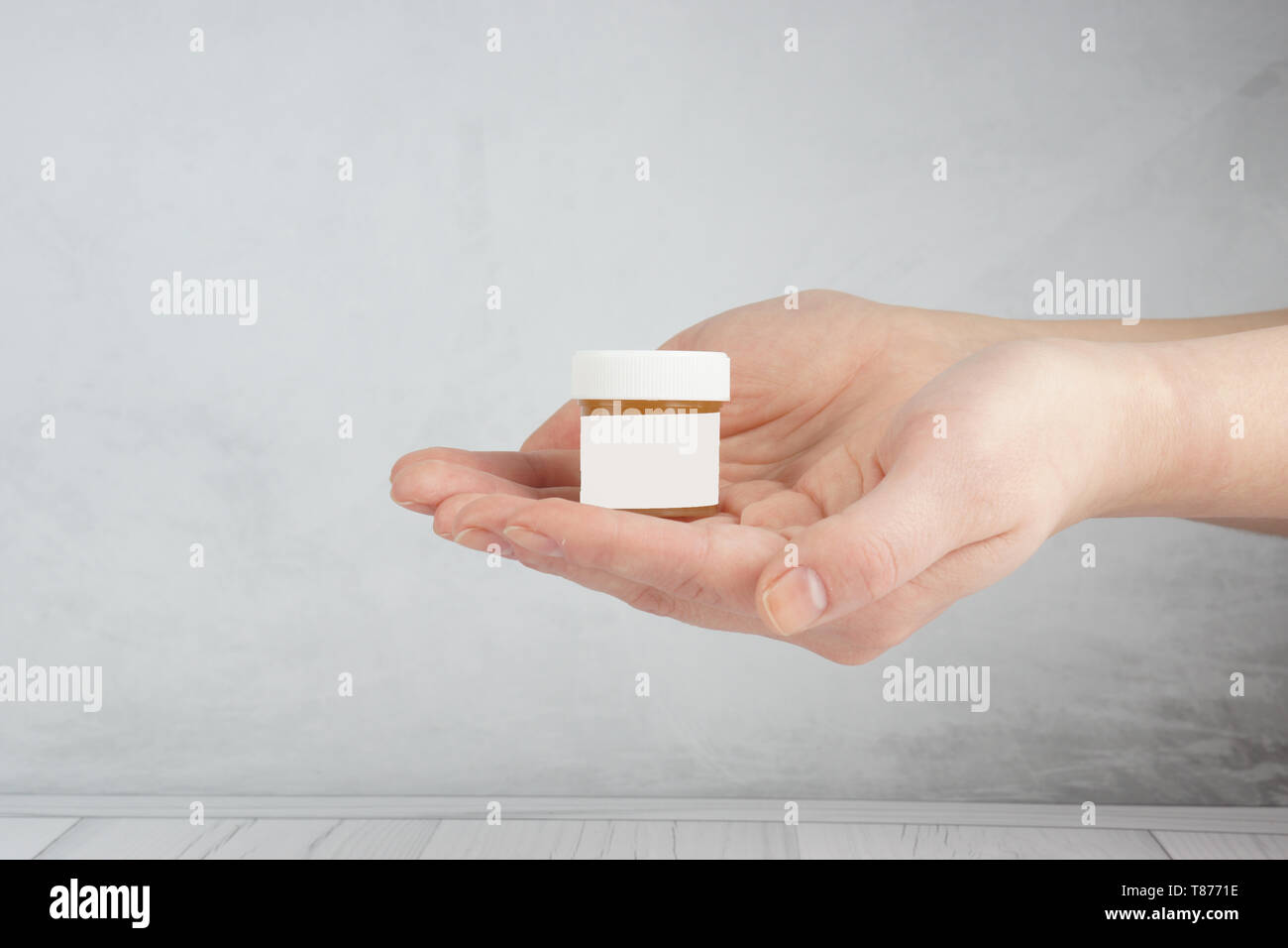 La publicité d'un produit cosmétique, soigné les mains tenant un pot avec un cosmétique. Banque D'Images