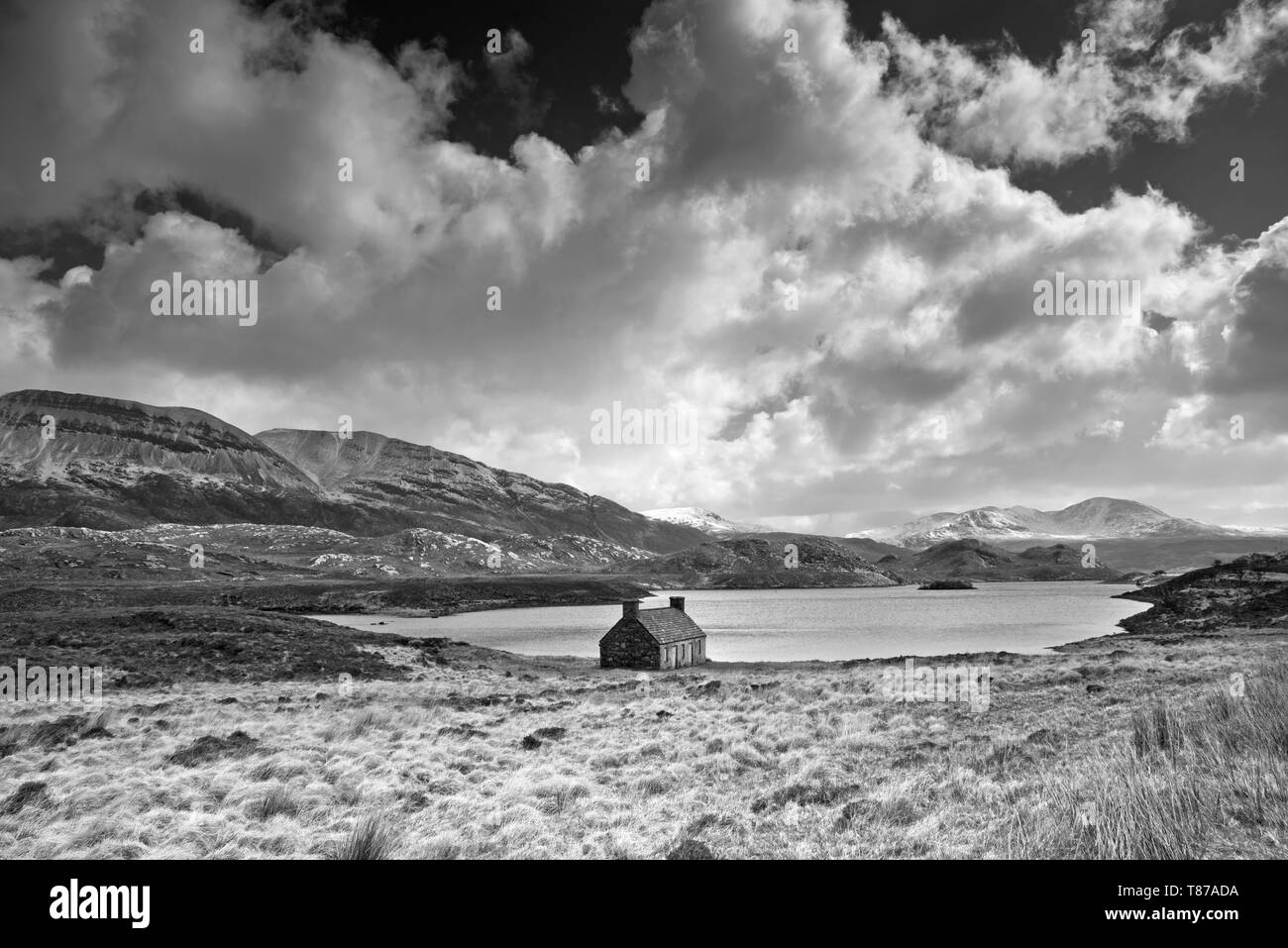 Vieux hut par Loch Stack, Arkle passant sur la gauche, Sutherland, les Highlands écossais, le Royaume-Uni, les rafales de vent, nuages orageux météo Avril, paysage spectaculaire. Banque D'Images