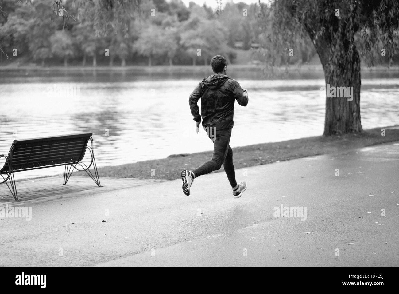 L'homme athlétique s'exécutant dans un jour de pluie. Banque D'Images