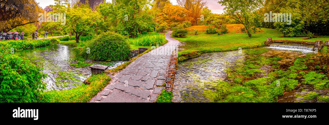 Pont de jardin eden enchanté sur l'étang en nymphe panoramique horizontal ou jardin Giardino della Ninfa en Latium - Italie Banque D'Images