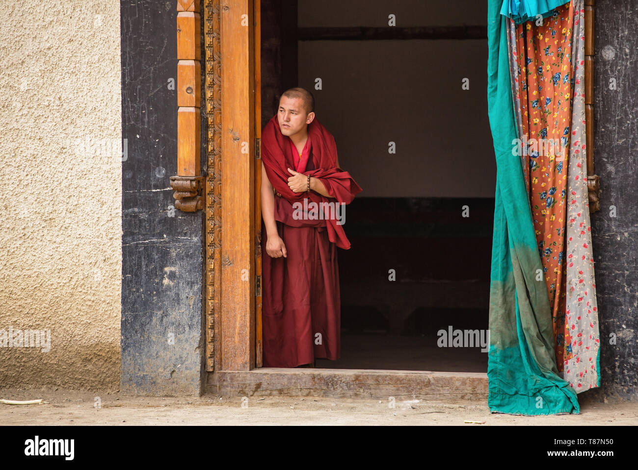 Moine bouddhiste tibétain regardant fête des masques de Lamayuru monastère porte dans Ladakh, India Banque D'Images