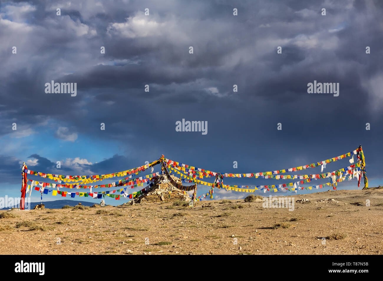 Old Stone stupa bouddhiste tibétain avec les drapeaux de prières au Ladakh, Inde. Banque D'Images