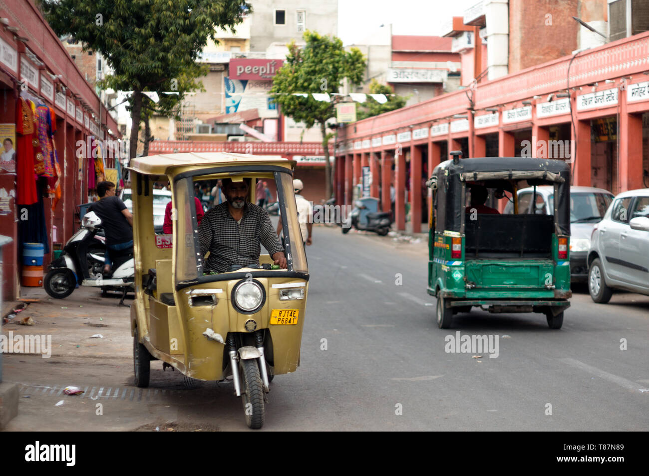 Pousse-pousse électrique déplacer sur les rues vides d'un marché à Jaipur Banque D'Images