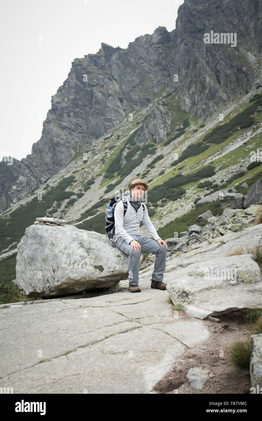 Sac à dos avec touristiques assis sur boulder en montagne Banque D'Images