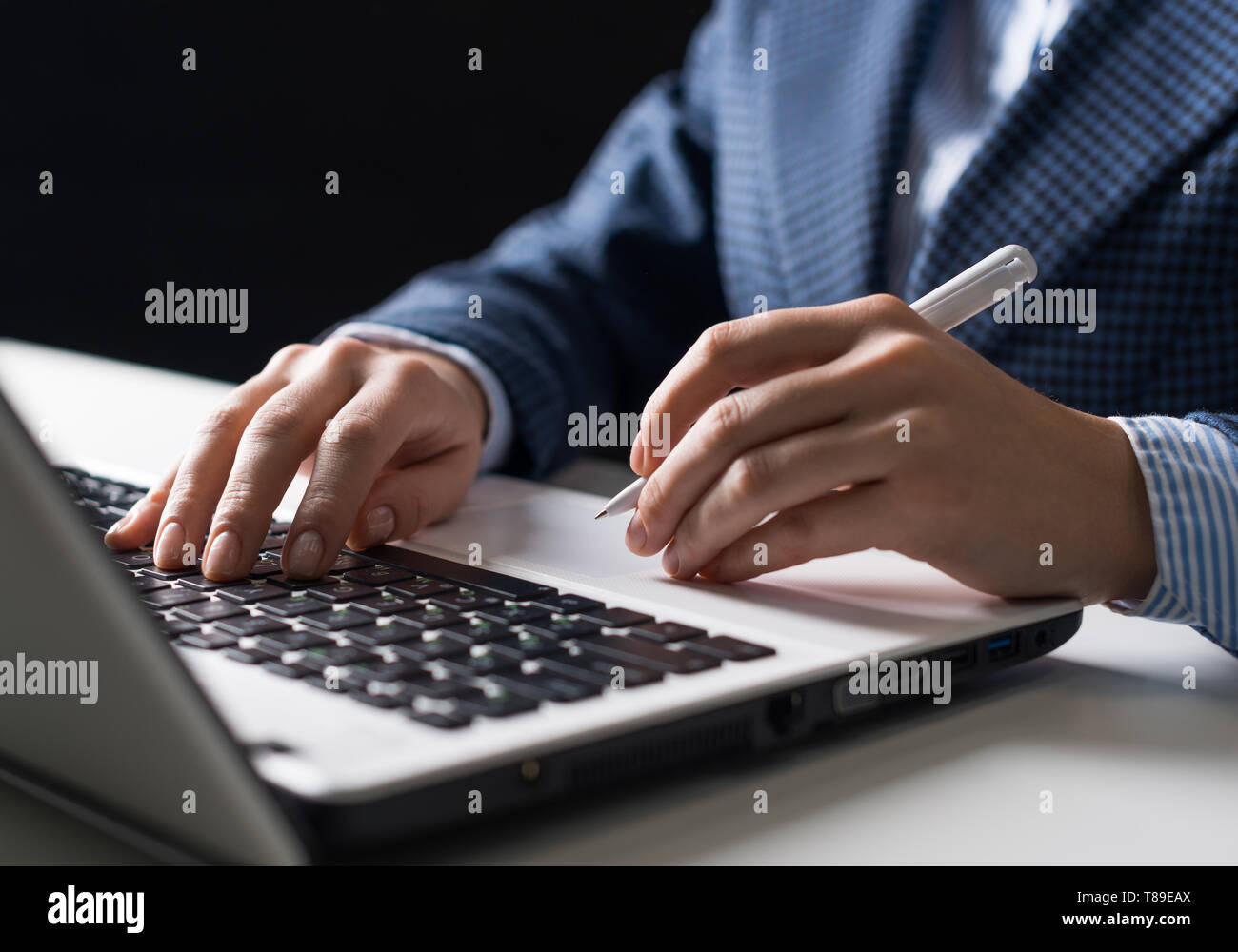 L'homme en costume sitting at desk with laptop Banque D'Images