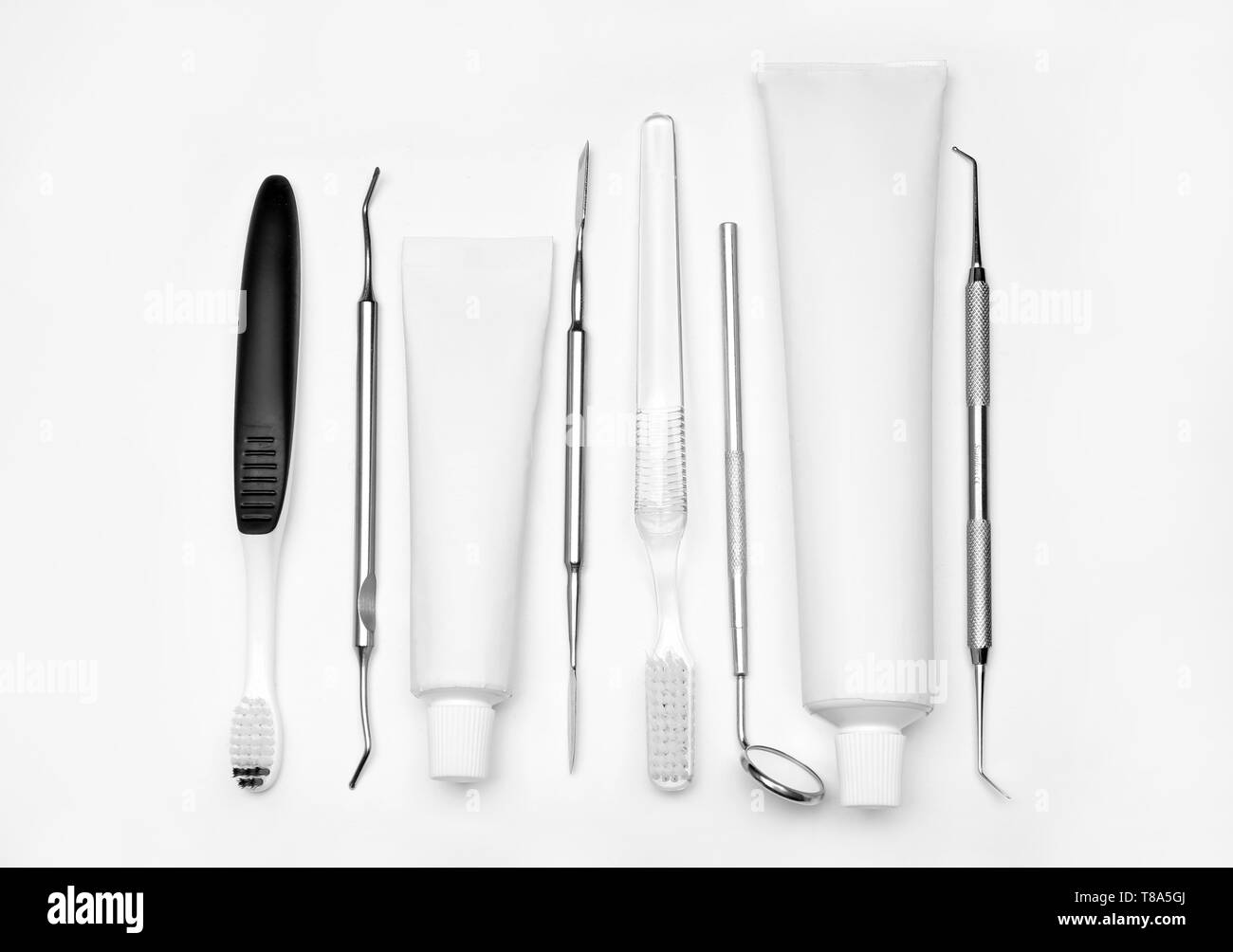 Outils de dentiste, brosses à dents et de la pâte sur le fond blanc Banque D'Images