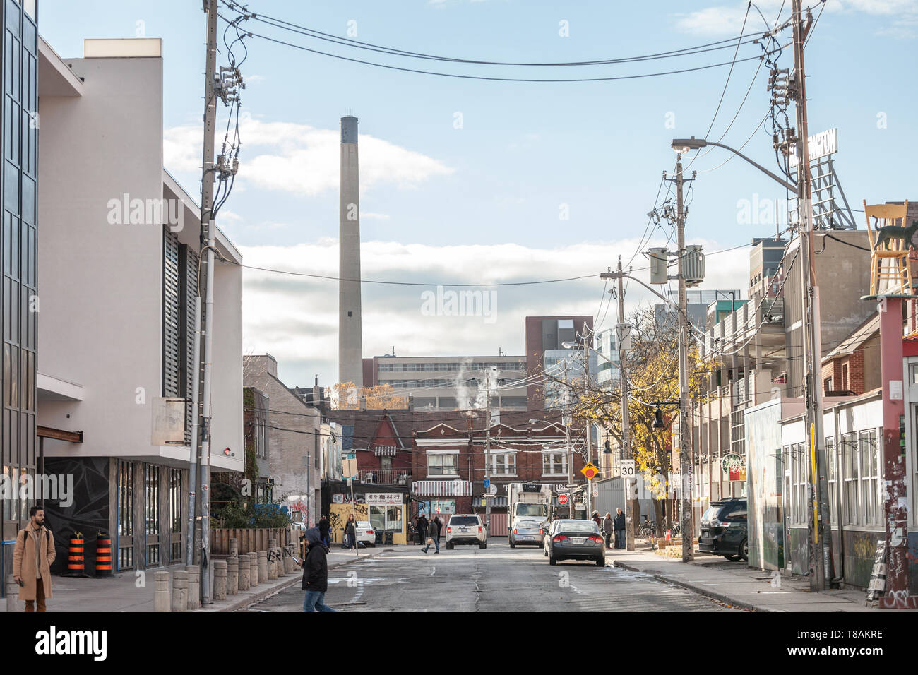 TORONTO, CANADA - 13 NOVEMBRE 2018 : Rue résidentielle typique d'Amérique du Nord dans la région de Kensington Market, avec la cheminée de l'hôpital Toronto Western en b Banque D'Images