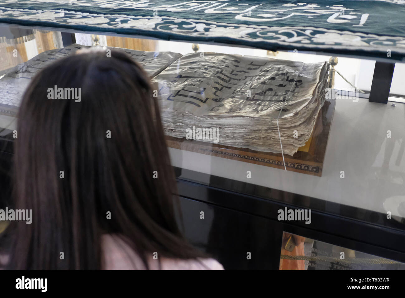 Un visiteur à Samarkand au manuscrit en caractères coufiques également connu sous le nom de Coran Ottoman, écrit dans la 8e ou 9e siècle et considérée comme la source principale du livre saint conservé dans la bibliothèque de l'Imam As dans la ville de Tachkent, capitale de l'Ouzbékistan Banque D'Images