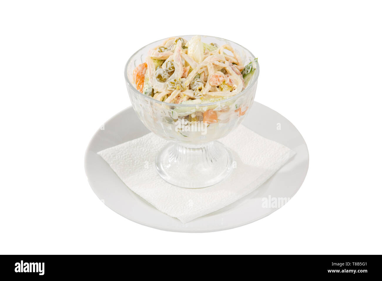 Salade Russe avec le jambon et le calmar, le concombre, les pois, les oeufs, la mayonnaise sur la plaque dans un grand bol, blanc fond isolé, side view Banque D'Images