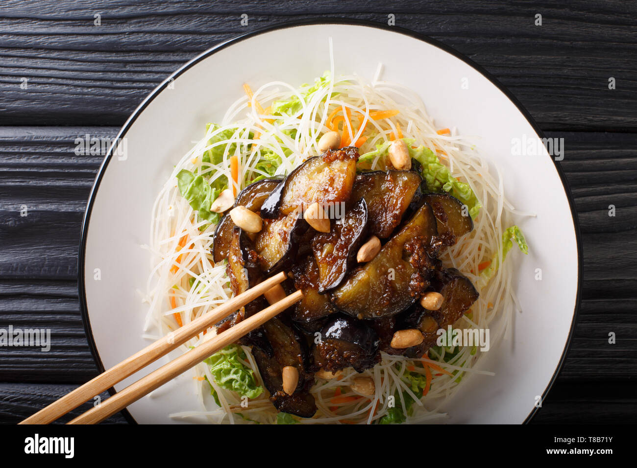 Nouilles de riz vietnamiens avec les aubergines et les cacahuètes sur une plaque sur la table. Haut horizontale Vue de dessus Banque D'Images